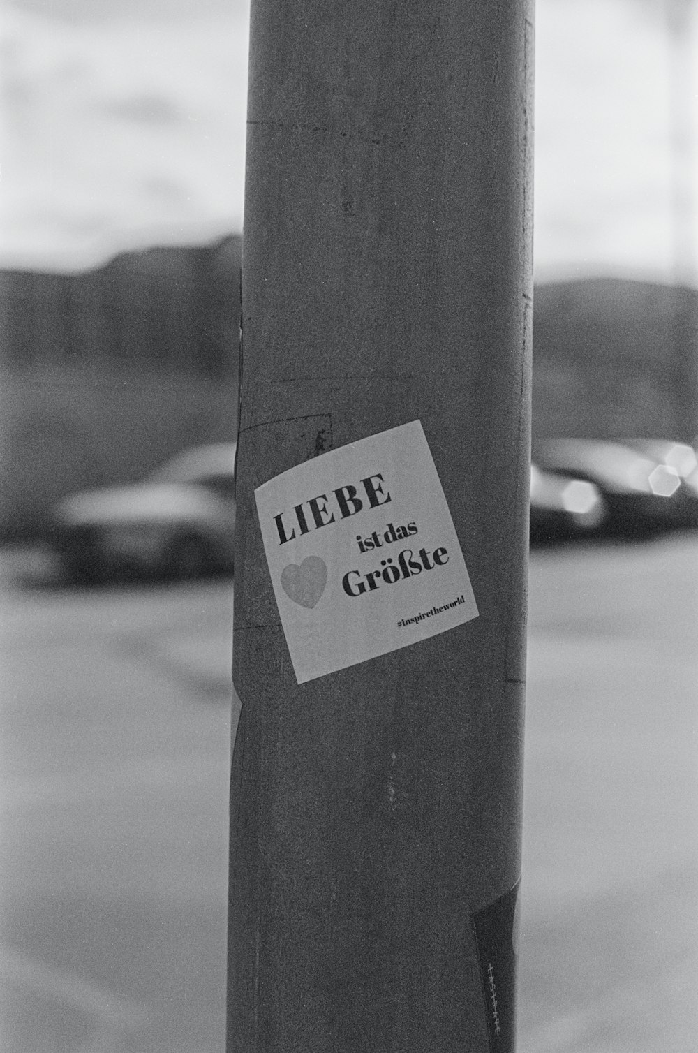 a black and white photo of a sticker on a pole