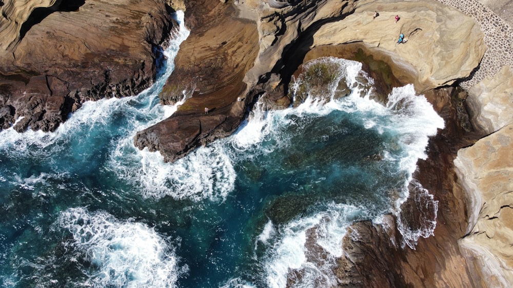 an aerial view of a beach with waves crashing against the rocks