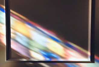 Bright rays of light streaming through a prism, casting multicolored reflections.