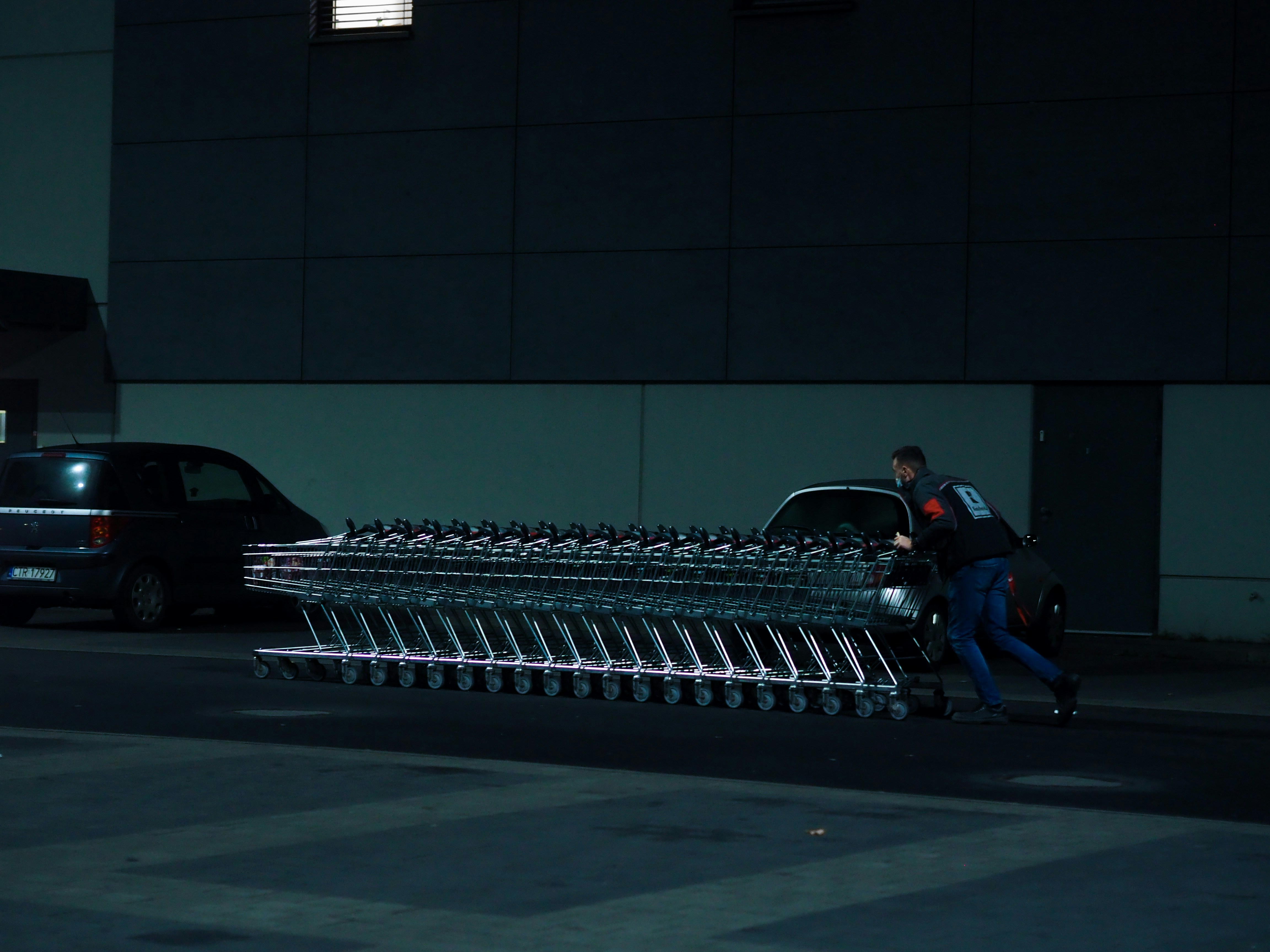 Un hombre empujando un carrito lleno de equipaje por una calle