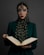 a woman in a green dress is holding a book