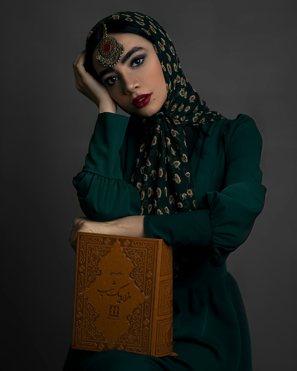 a woman in a green dress holding a book