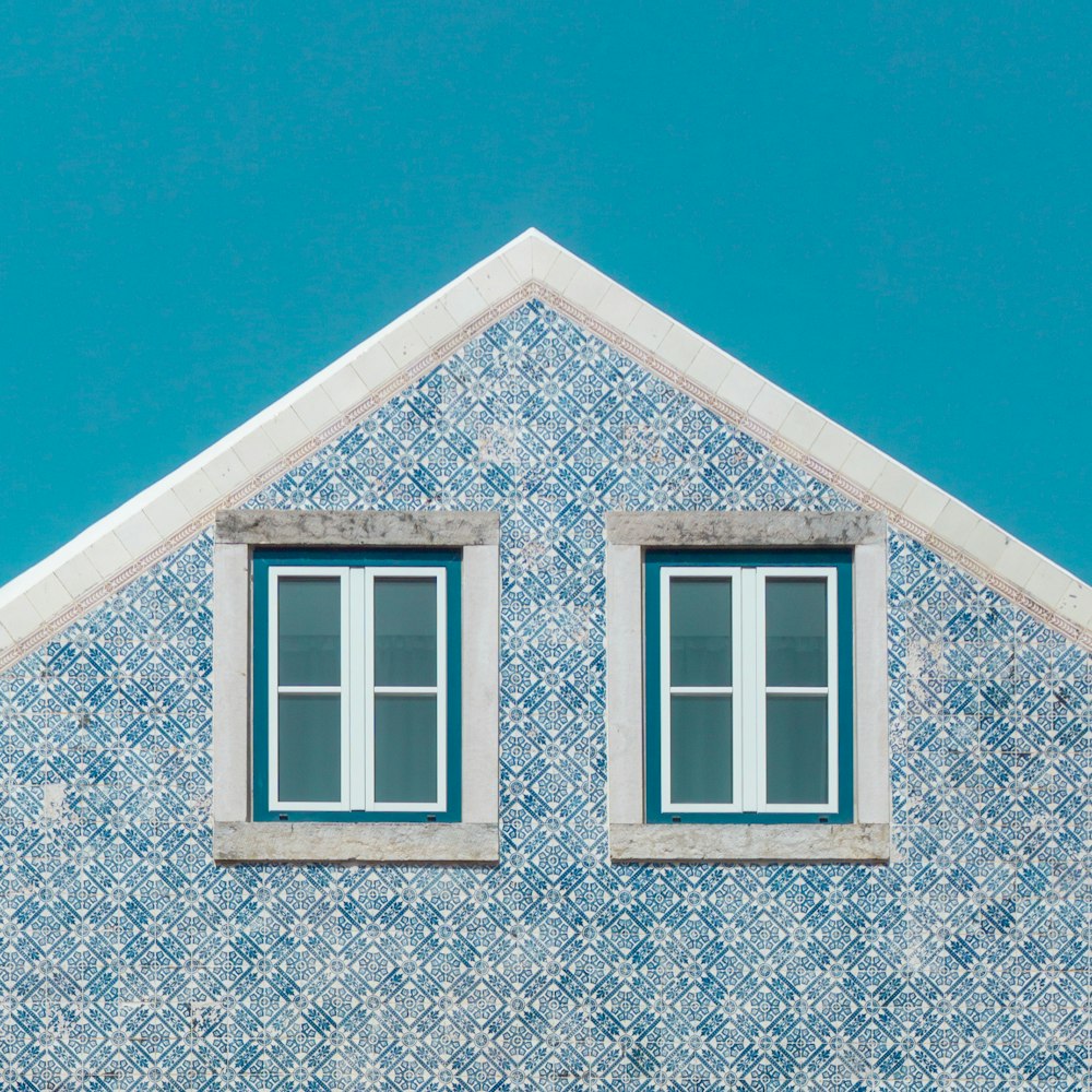 a blue and white building with two windows