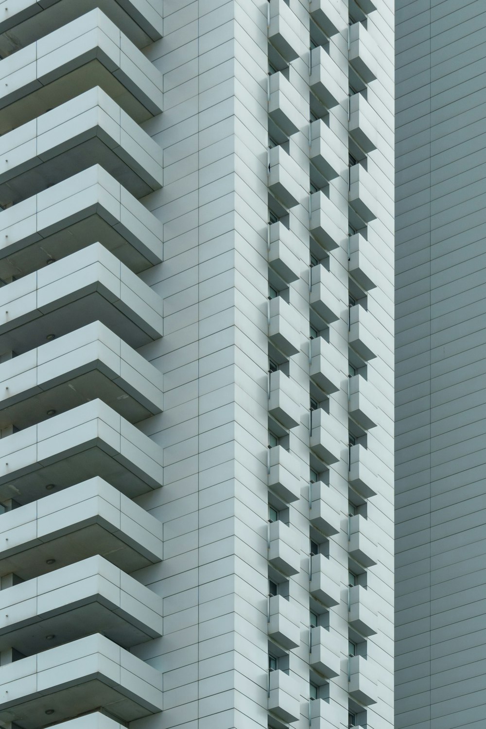 a tall white building next to a tall white building