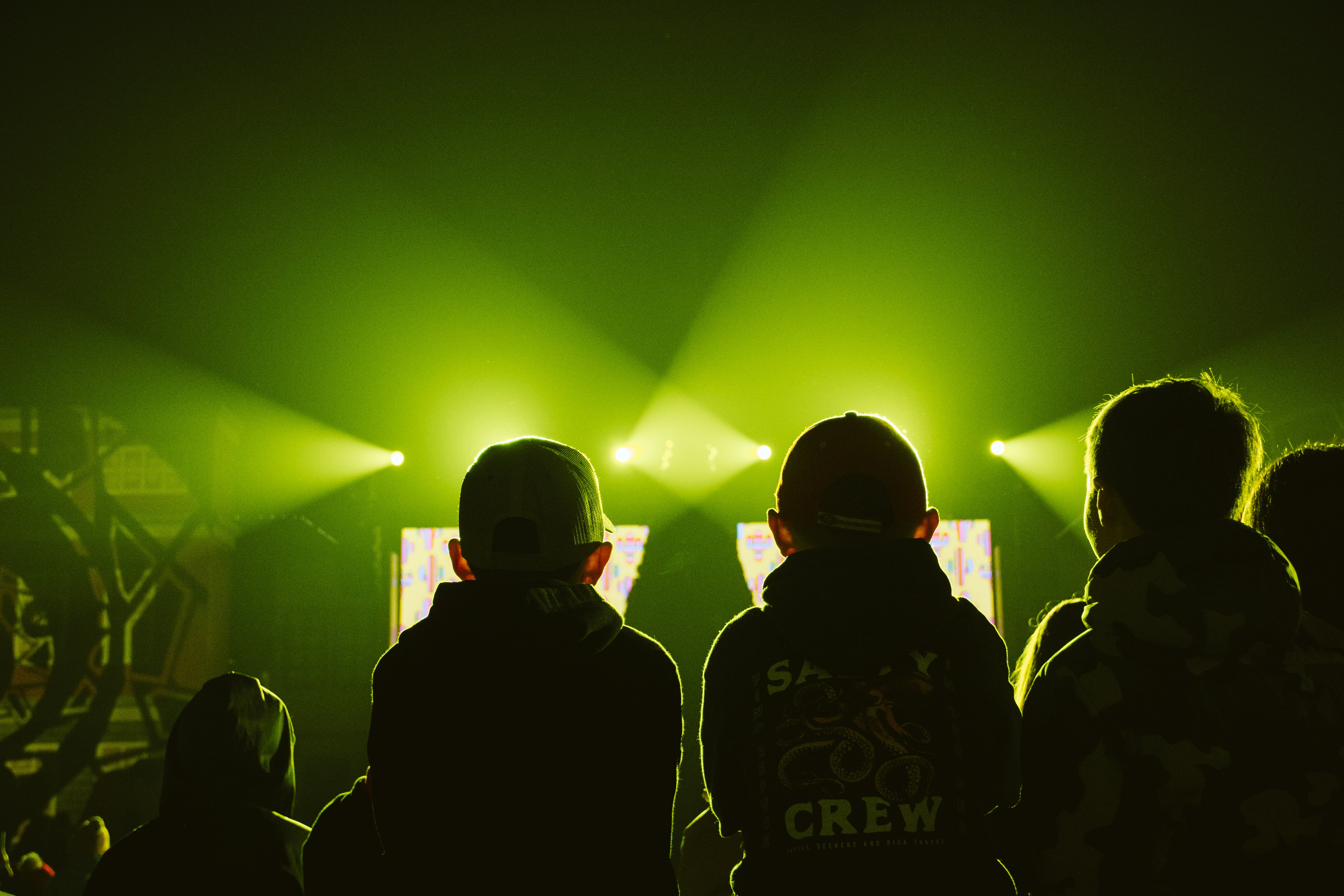 4 Music Festival Survival Tips From People Who’ve Worked Backstage – a group of people standing in front of a green light