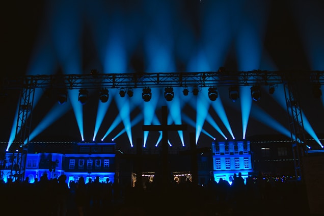 A vibrant scene of people enjoying a lively night event with dynamic blue and black lighting.