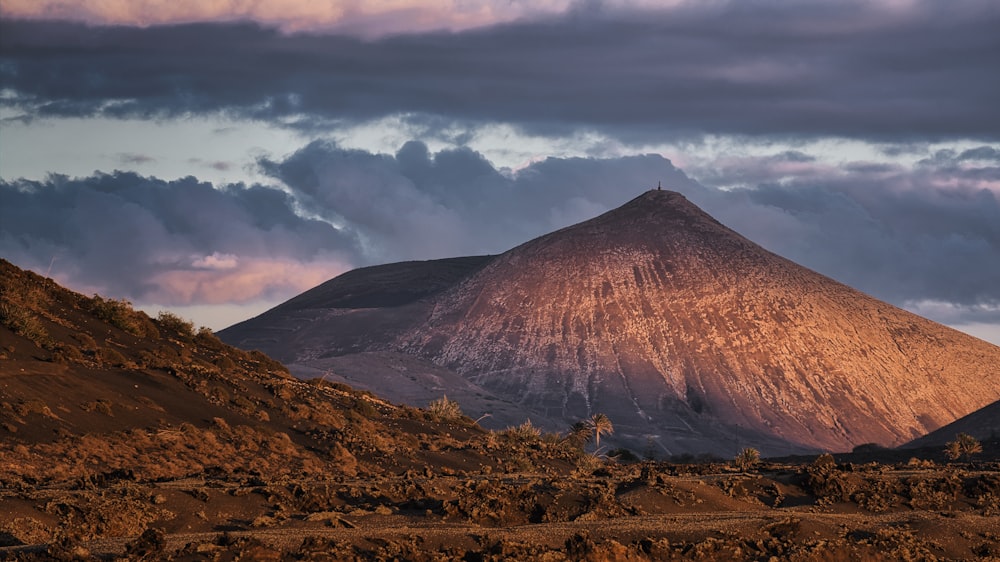 a mountain with a cloudy sky in the background