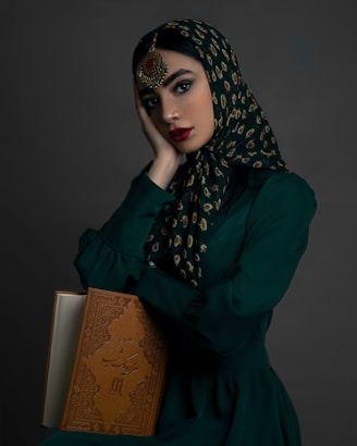 a woman in a green dress holding a book