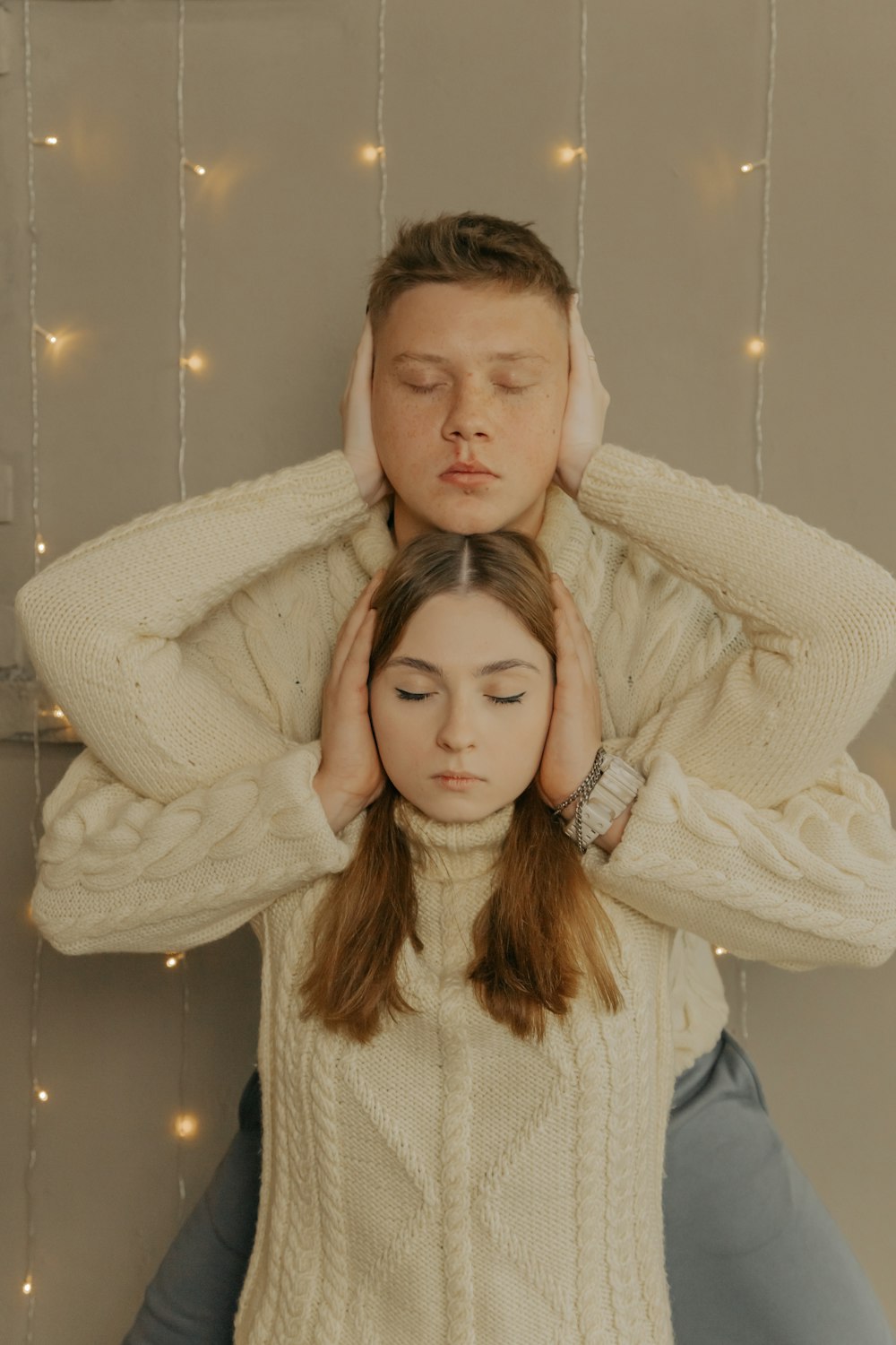 a man and a woman who are covering their ears