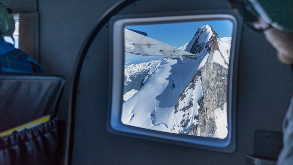 a man looking at a television screen with a mountain in the background