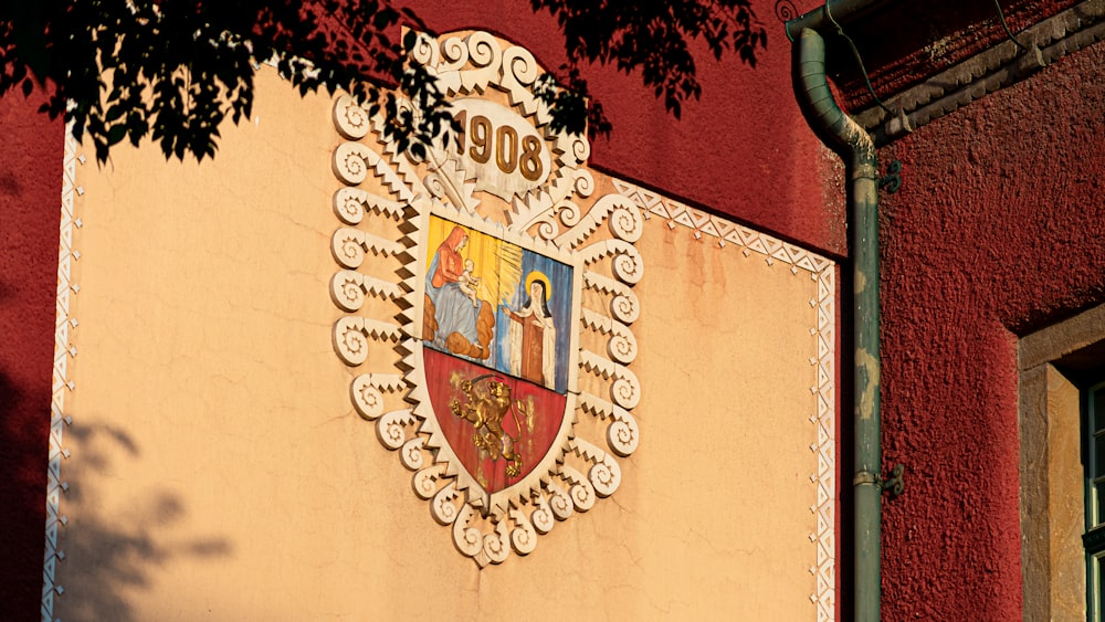 a red and yellow building with a coat of arms on it