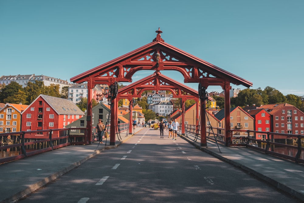 a wooden bridge with a red building in the background