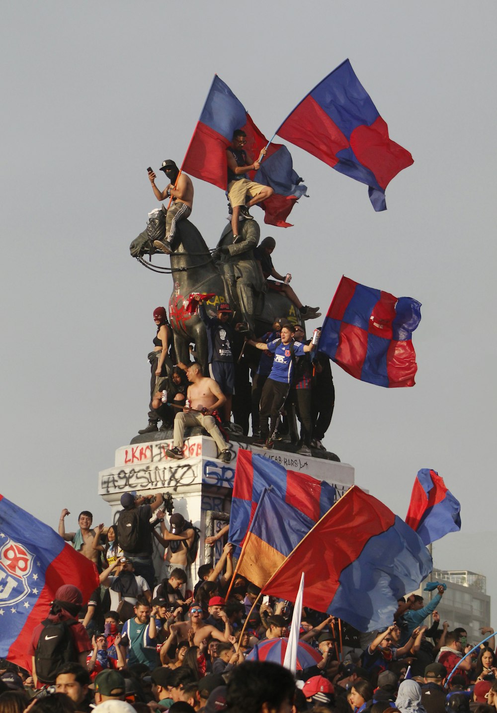 a crowd of people standing on top of a statue