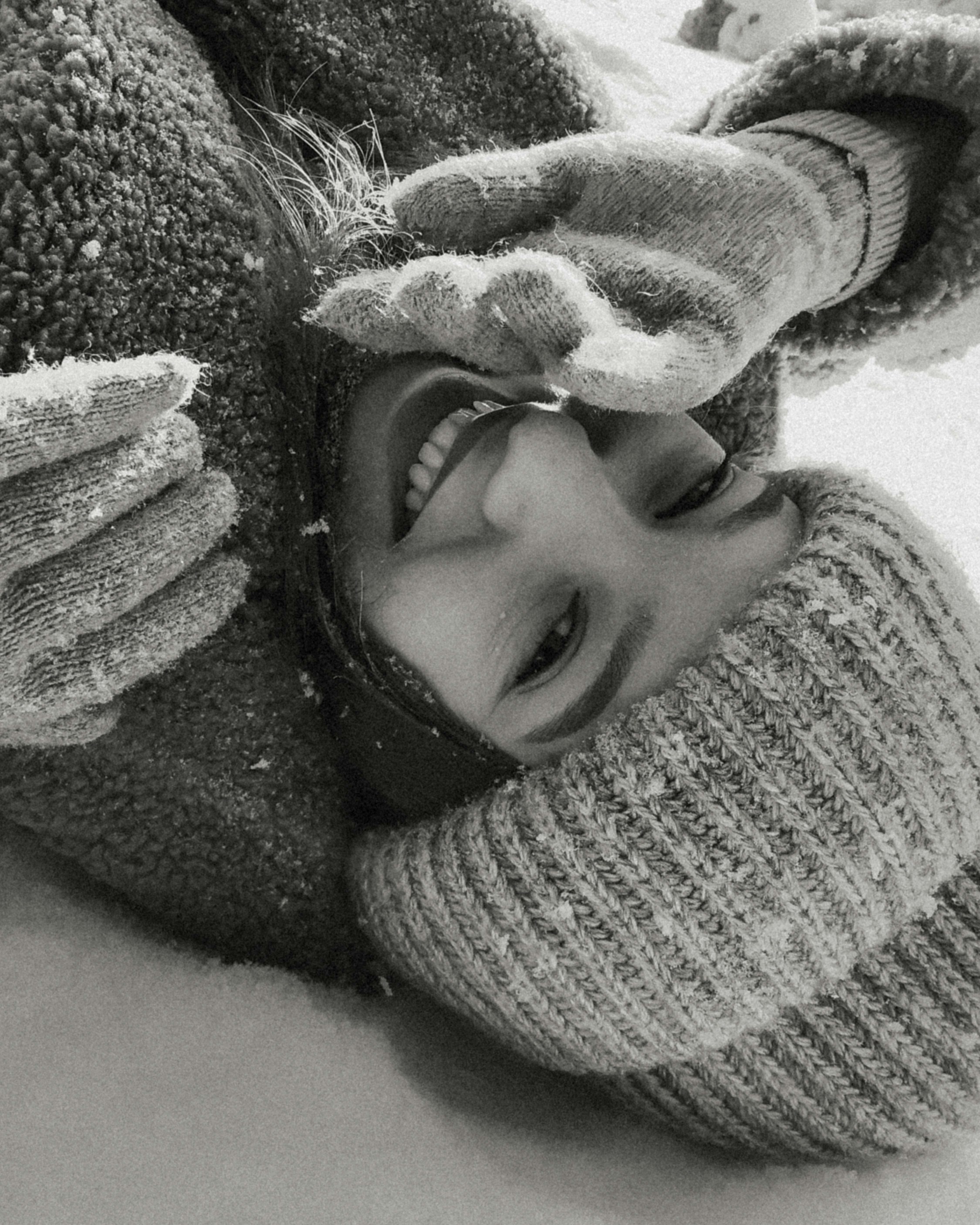 a young boy is laying down in the snow
