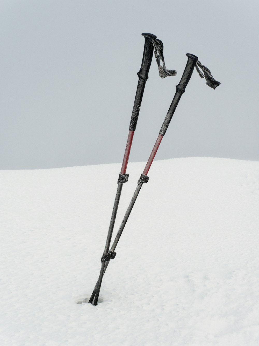 two ski poles sticking out of the snow