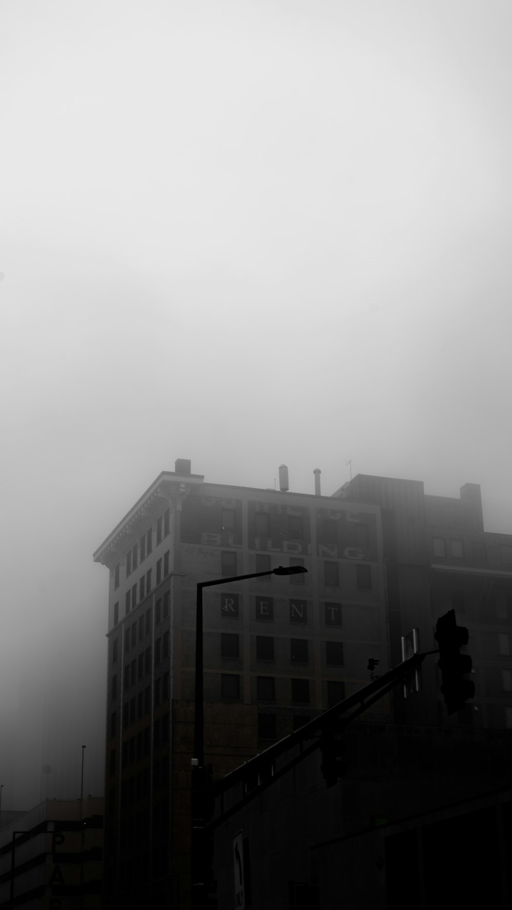 a black and white photo of a foggy city