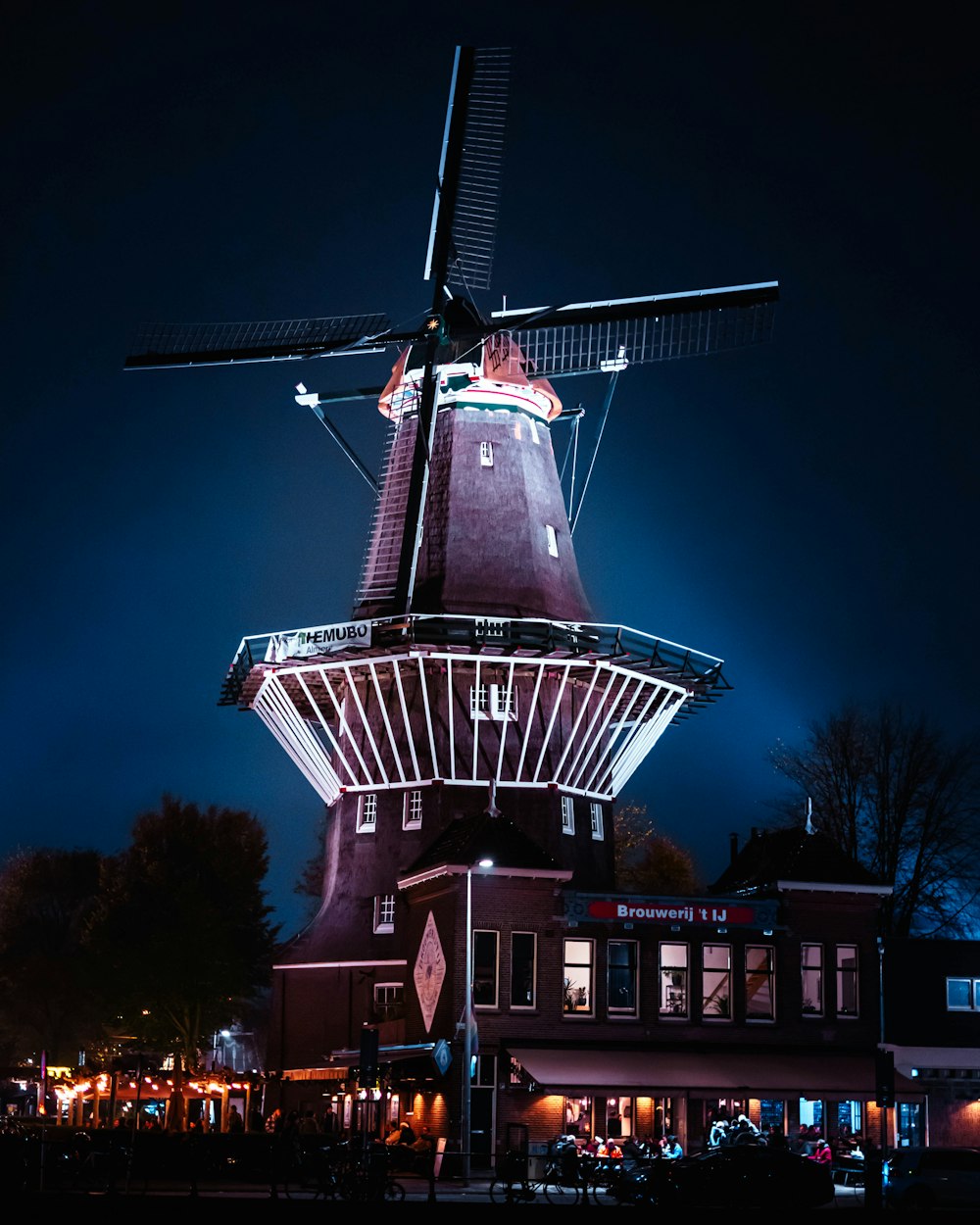 a windmill is lit up in the dark