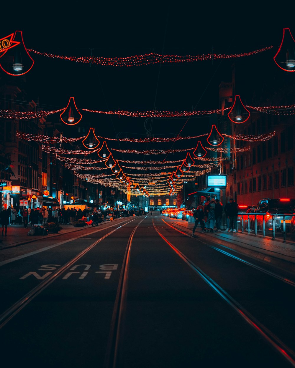 a city street is lit up with christmas lights