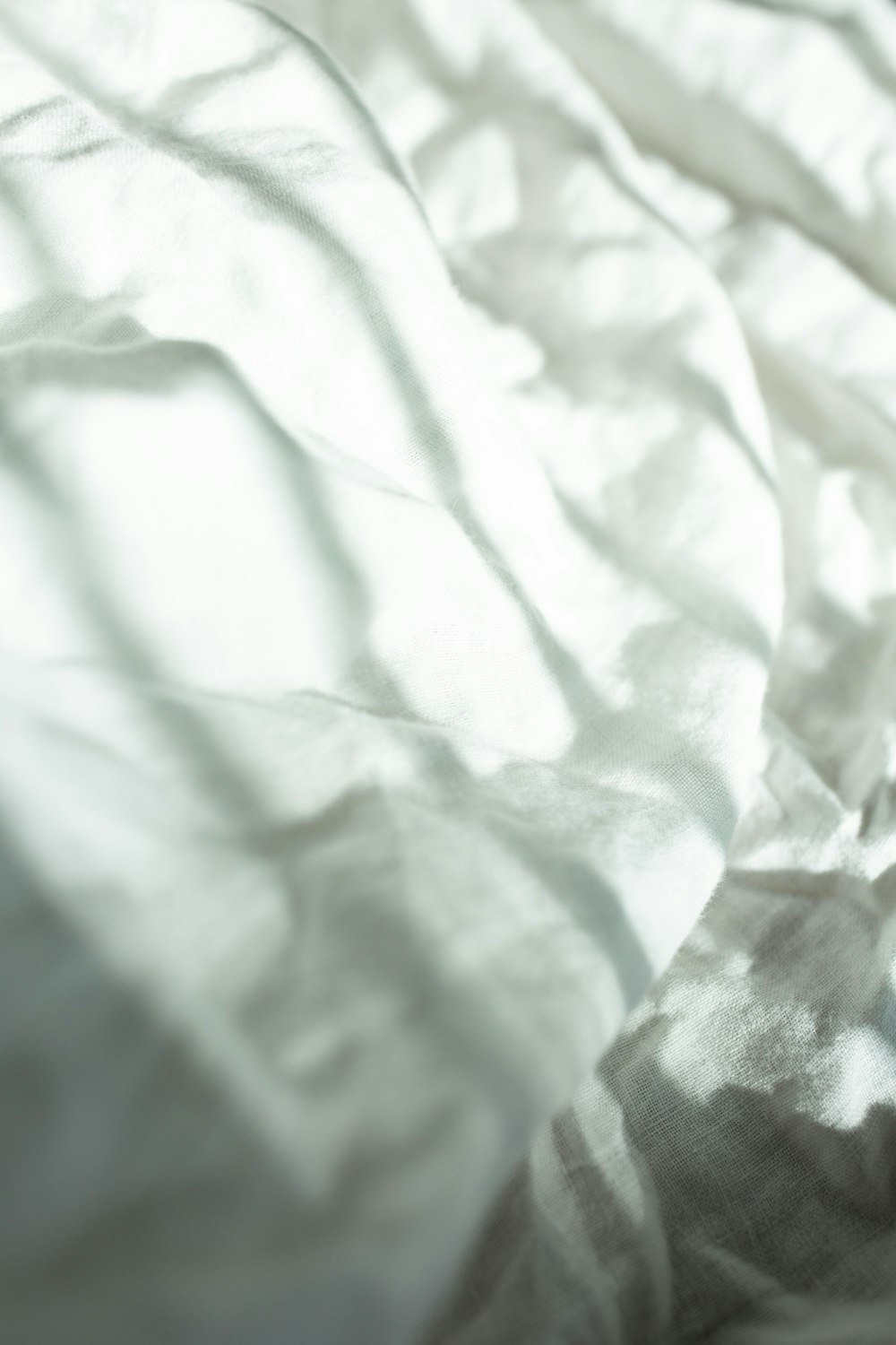 a close up of a bed with a white comforter