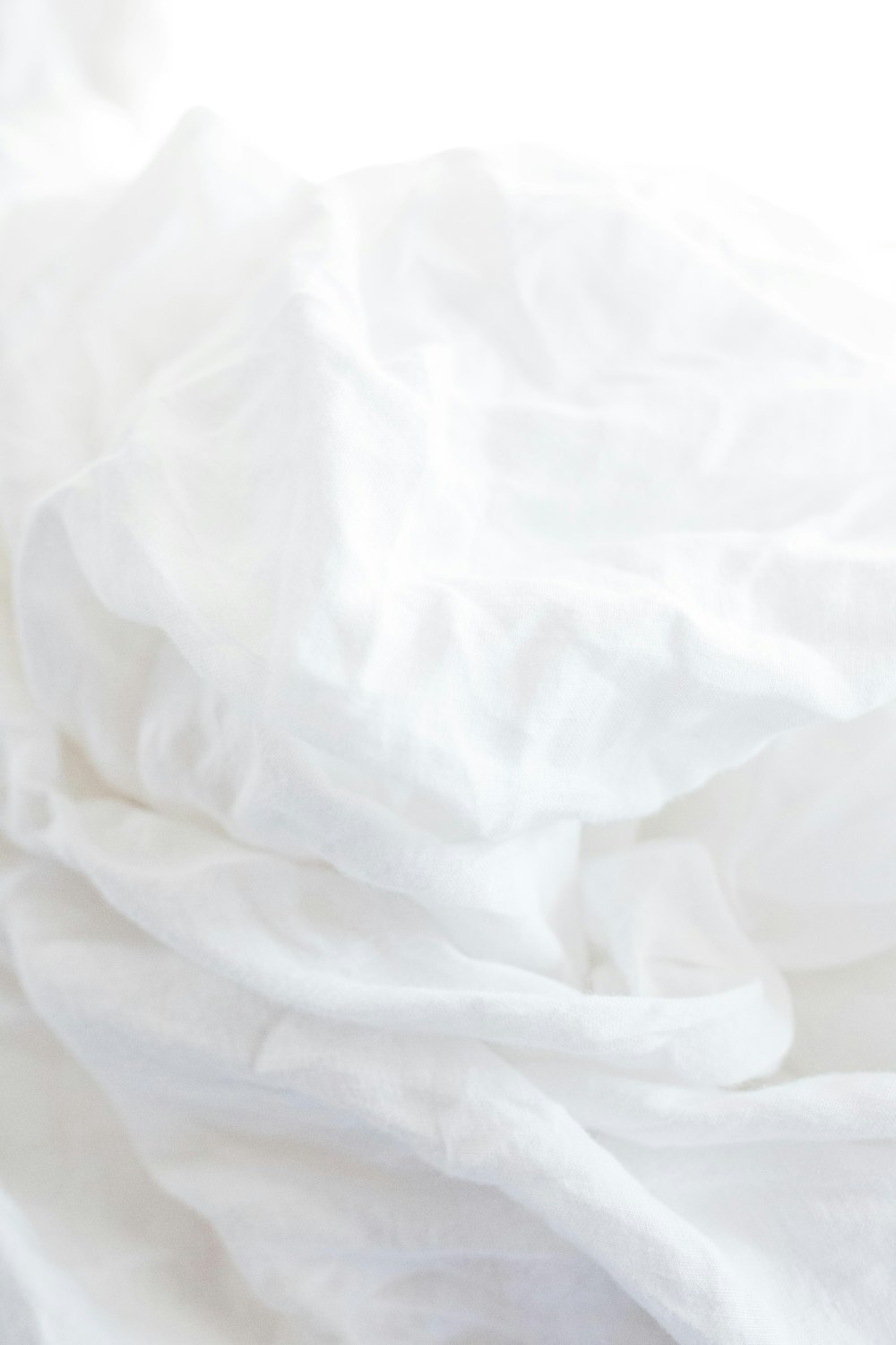 a close up of a bed with white sheets