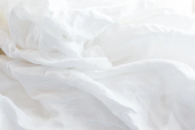 a close up of a bed with white sheets