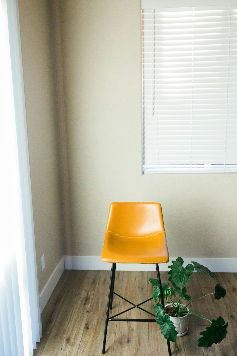 Una silla amarilla sentada en una habitación junto a una ventana