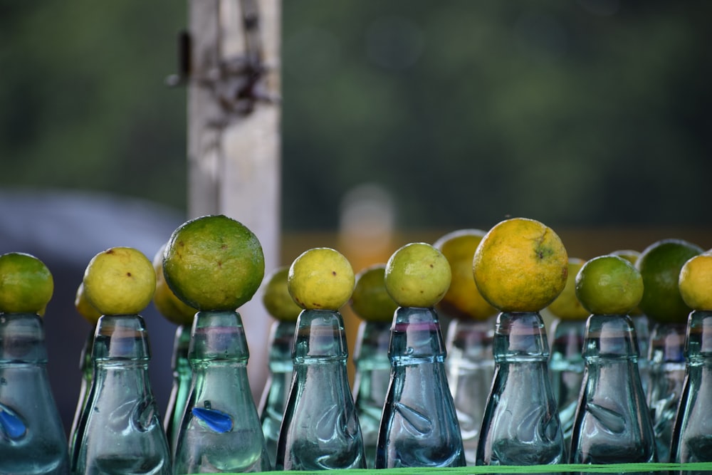 a row of glass bottles filled with lemons and limes