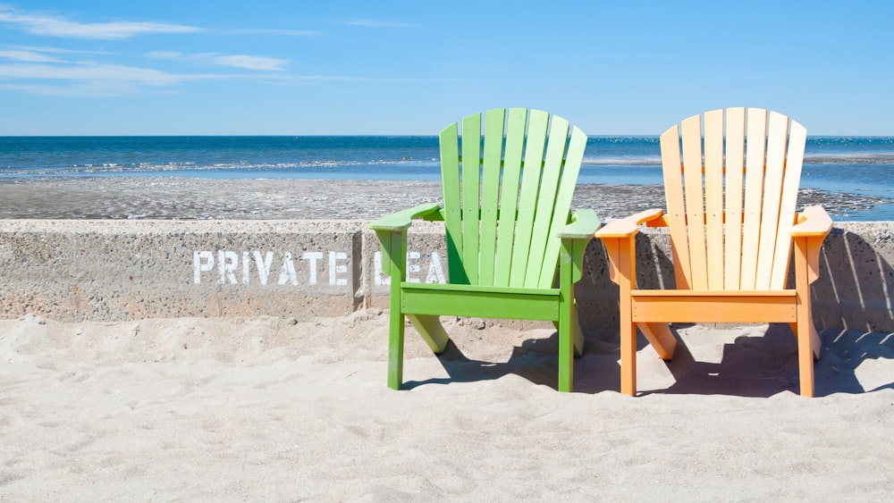모래 해변 위에 앉아있는 두 개의 의자