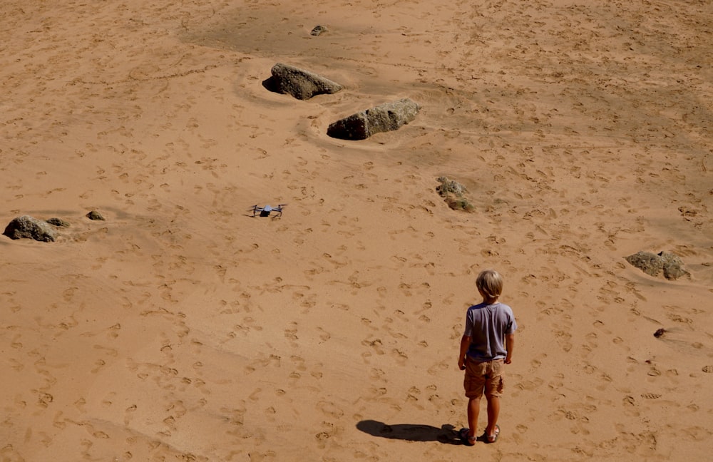 a man standing in the middle of a sandy area