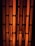 Vertical, elongated openings in a black metal grid with an orange, glowing background, creating an industrial appearance.