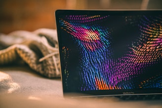 a laptop computer sitting on top of a bed