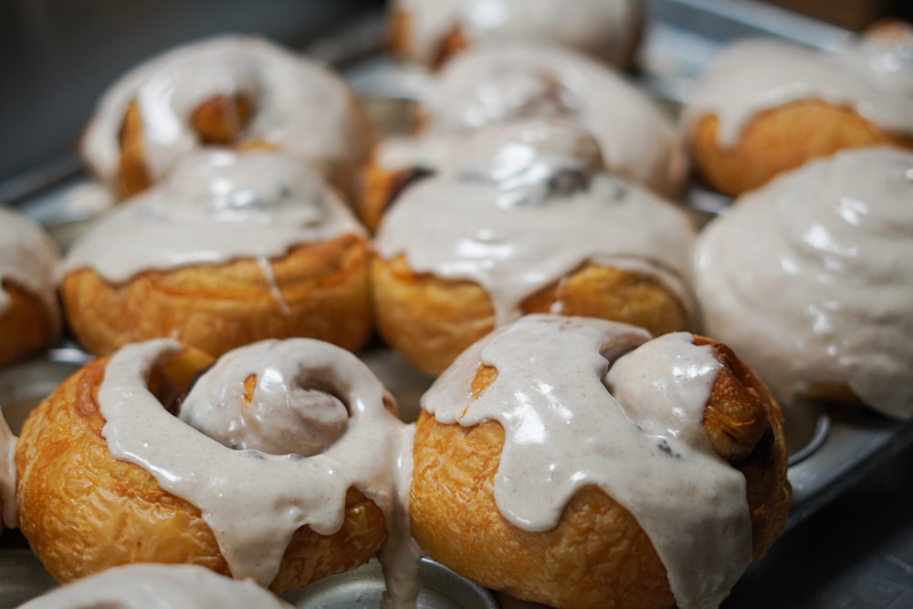 a close up of a tray of doughnuts with icing