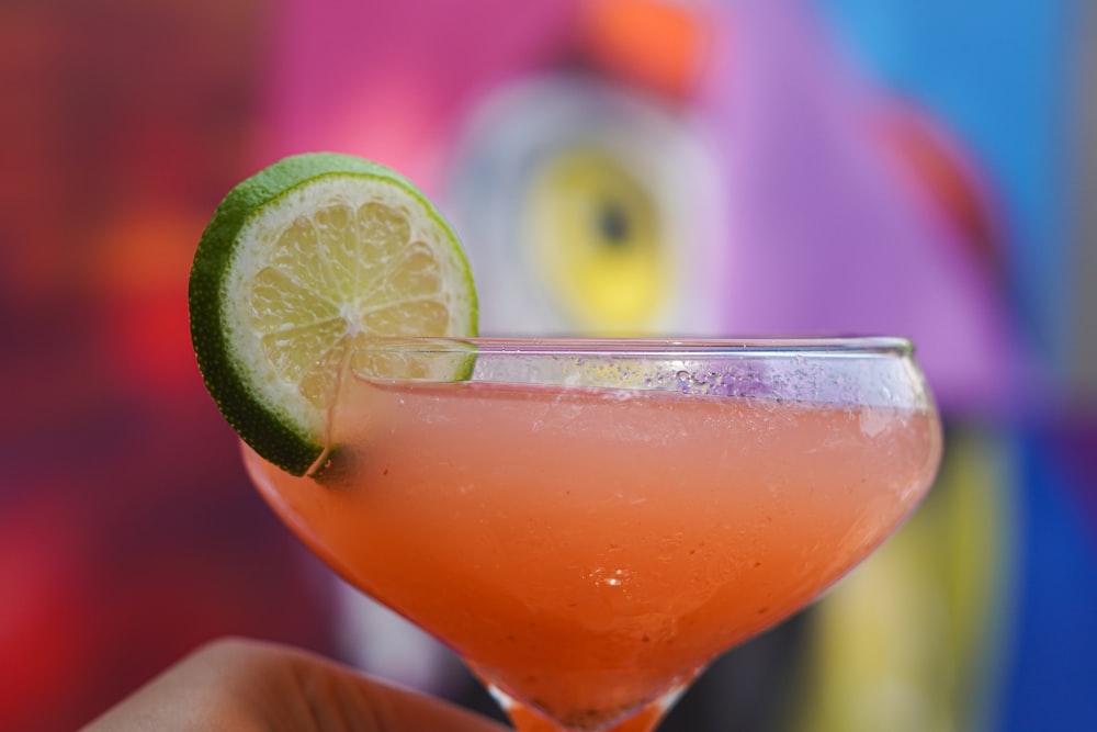 a close up of a person holding a cocktail