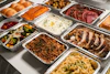 a table topped with lots of trays of food