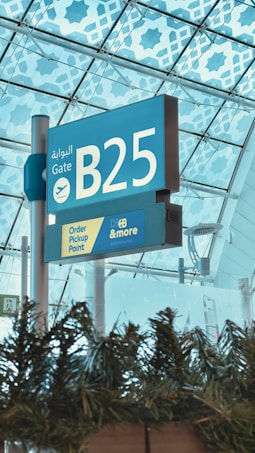 a blue and white sign under a glass roof
