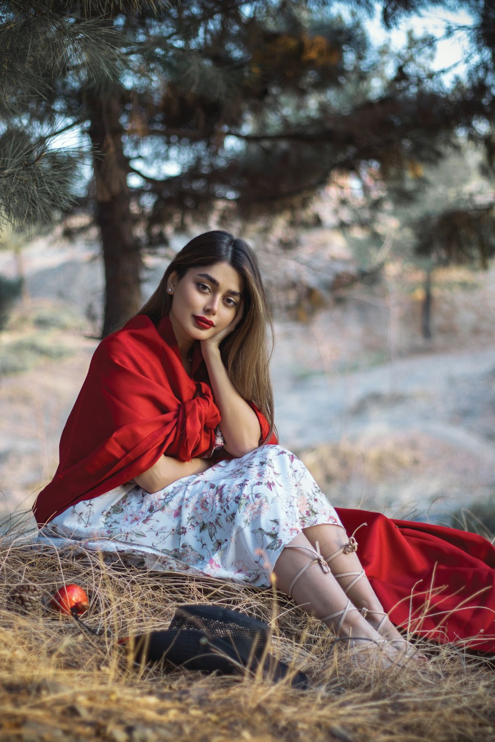 a woman in a red dress sitting in a field