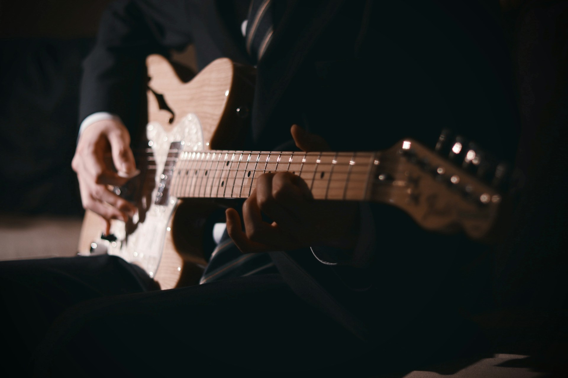a man in a suit playing a guitar