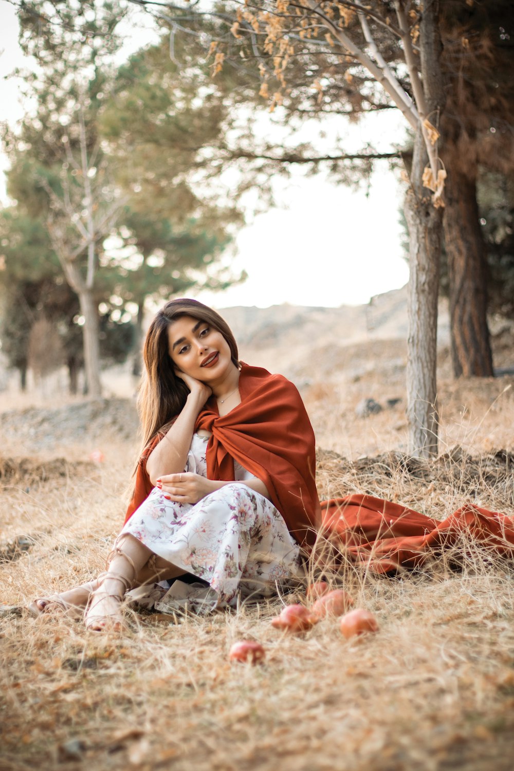 a woman sitting on the ground in a field