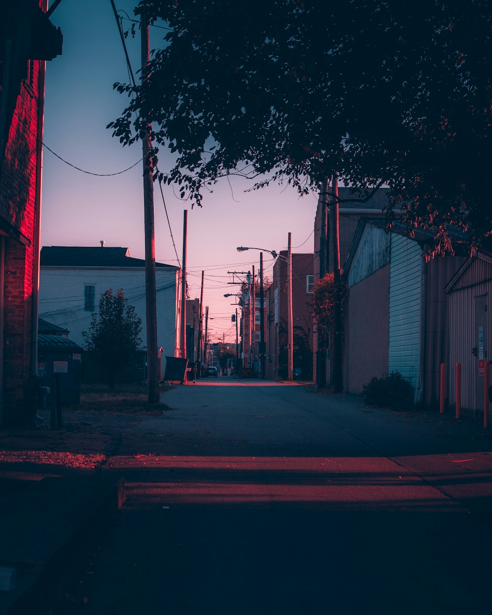 a dark street with a red light at the end of it