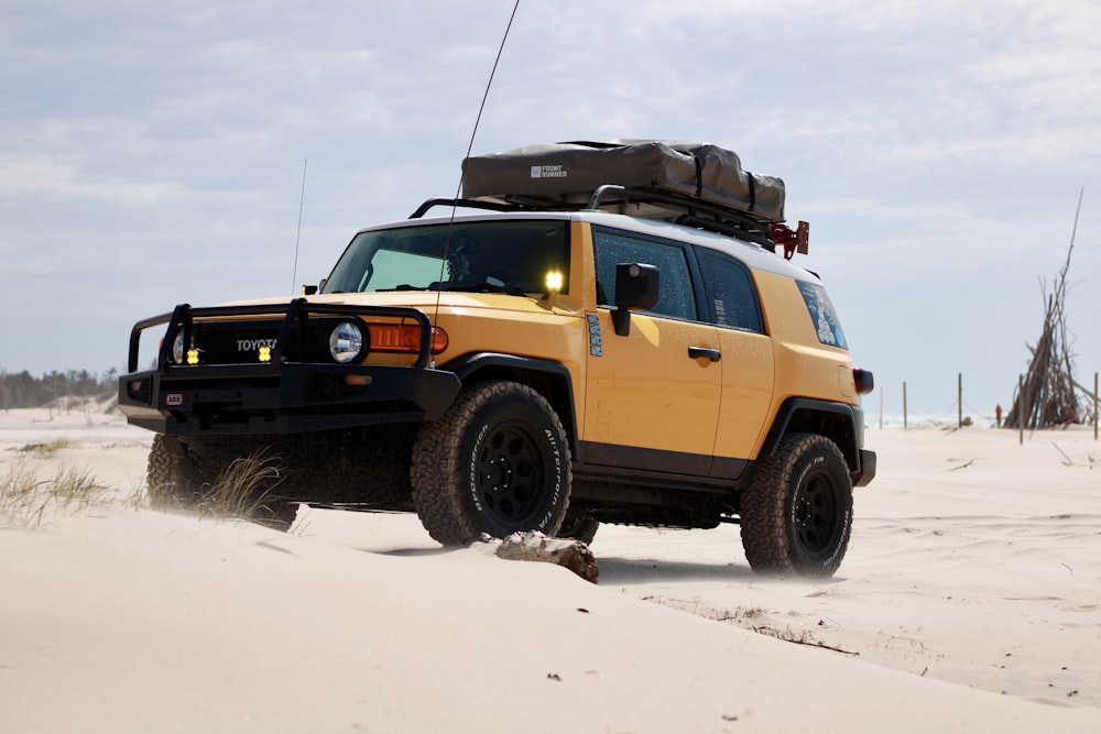 a yellow vehicle driving through the sand dunes