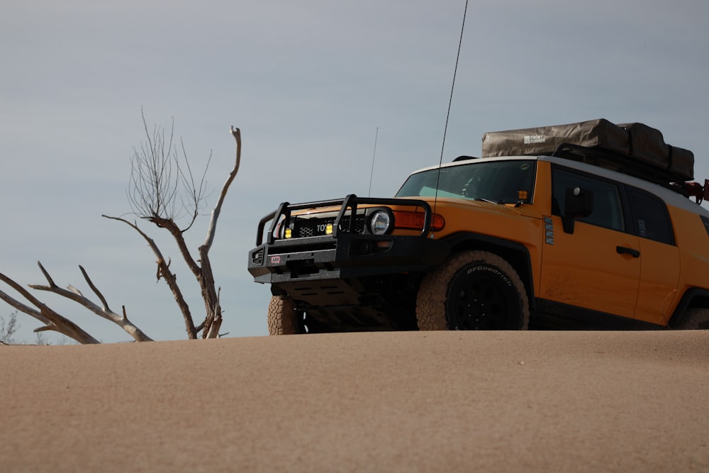 a yellow vehicle with a roof rack and luggage on top of it