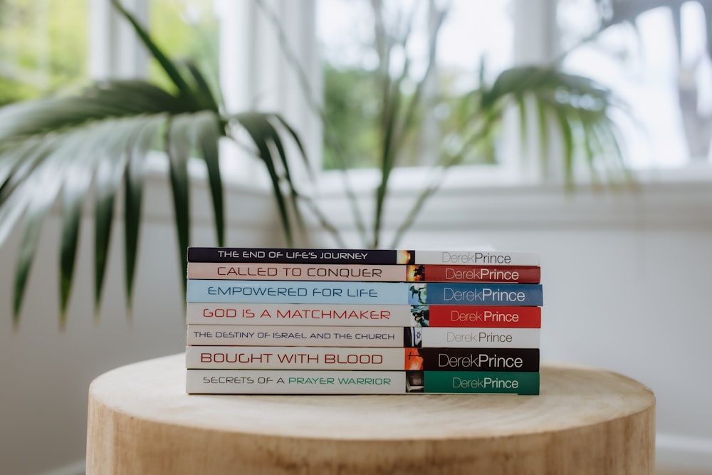 a stack of books sitting on top of a wooden table