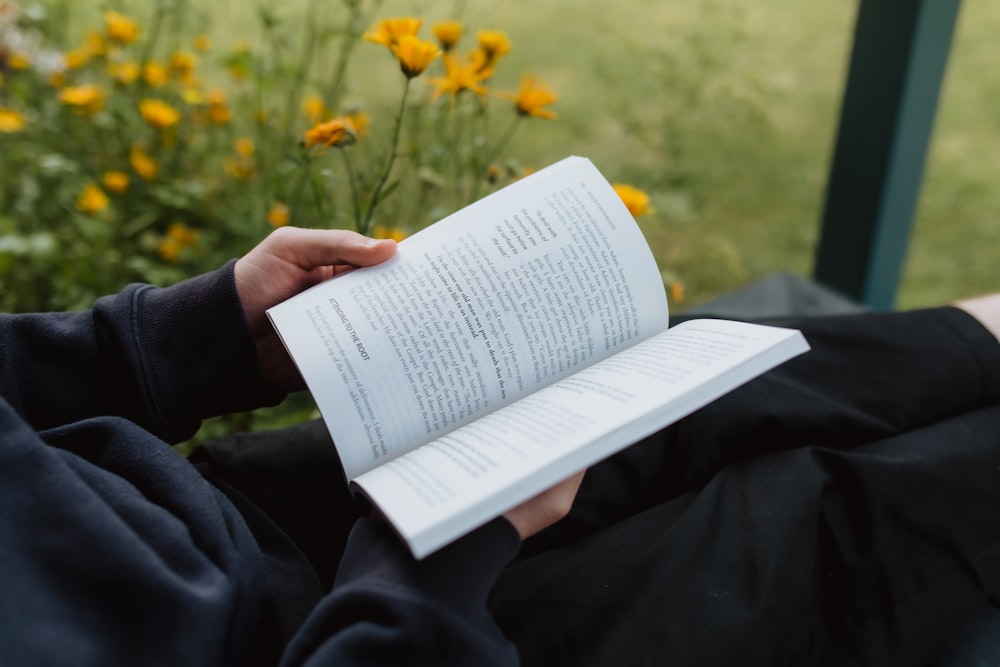 eine Person, die ein Buch in der Hand hält