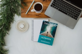 a book sitting on top of a desk next to a laptop