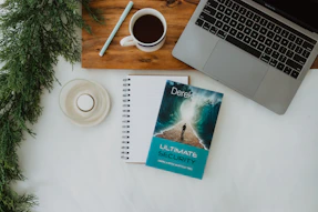 a book sitting on top of a desk next to a laptop