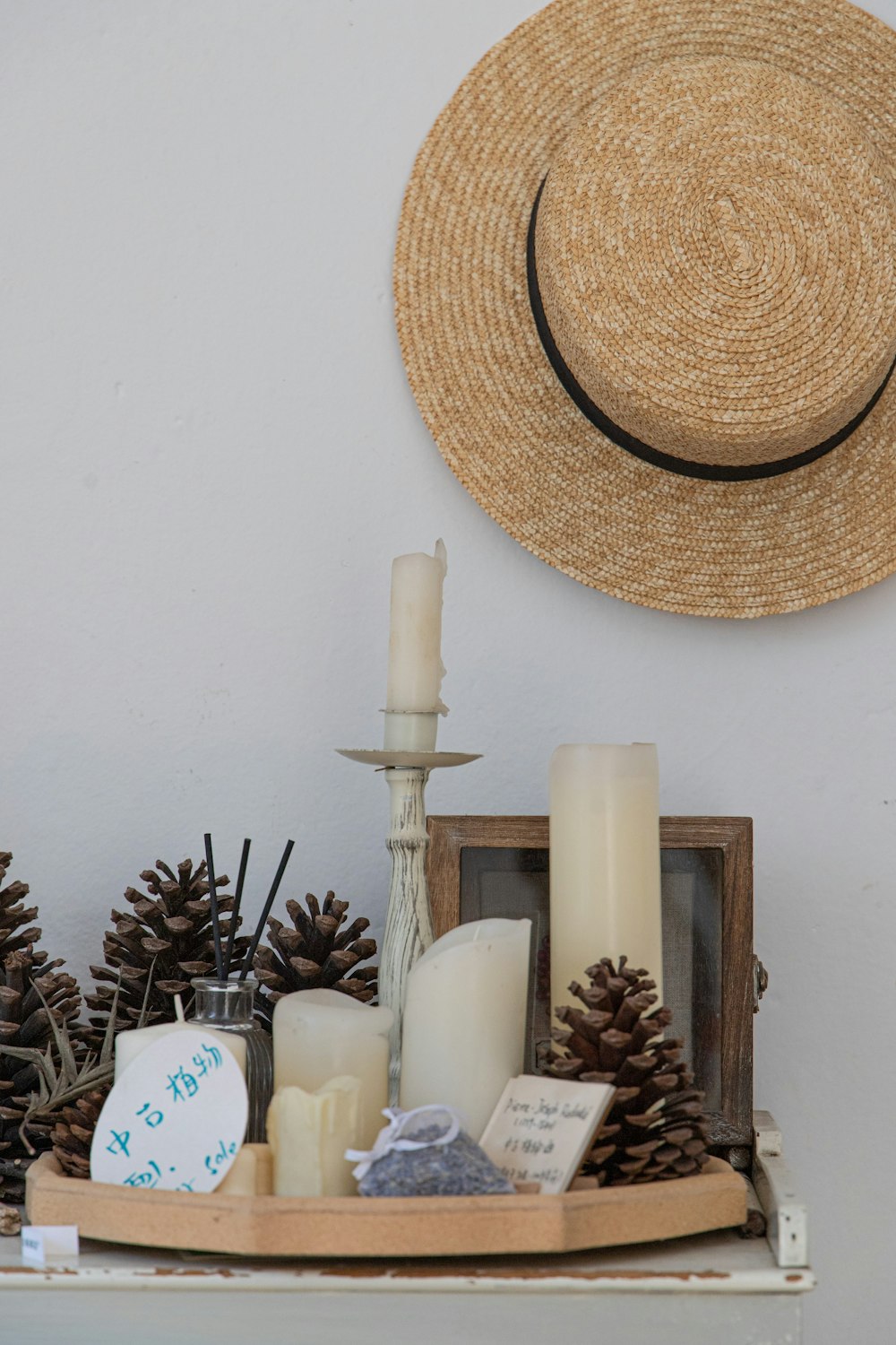 a hat on top of a table with candles and pine cones