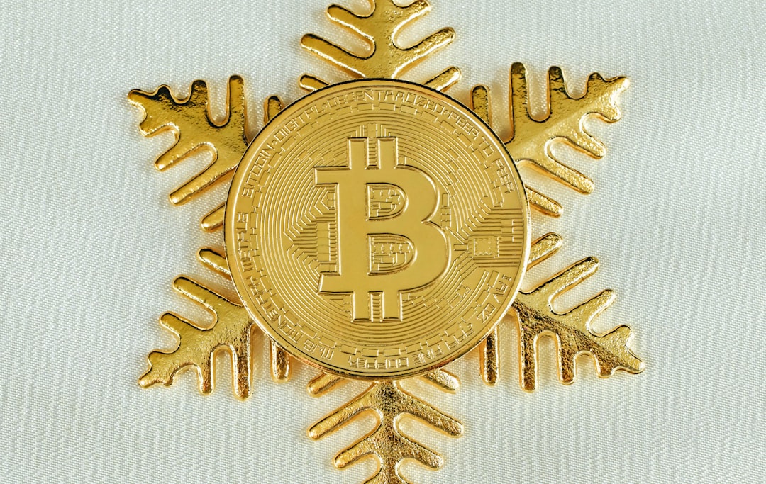 A gold Bitcoin on top of a gold snowflake 