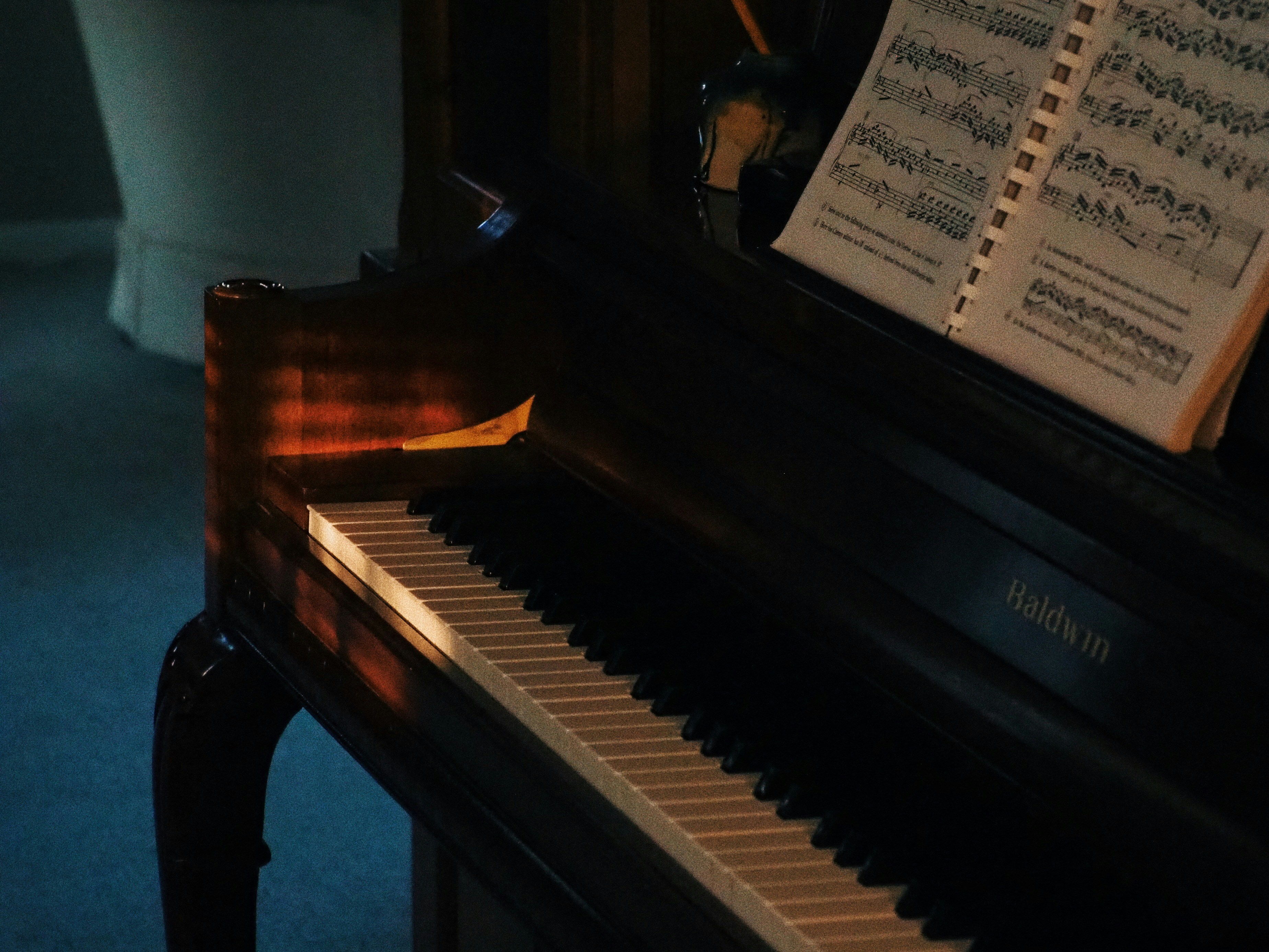 Musical score on piano in dim room, warm amber light