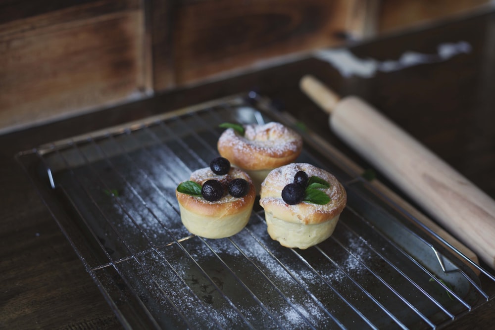 three pastries on a baking tray with a rolling pin