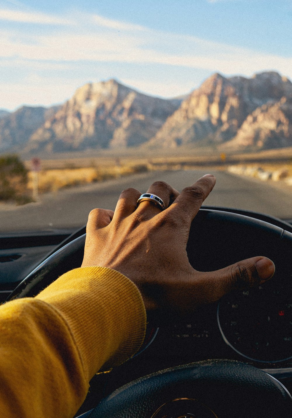 a person driving a car with mountains in the background